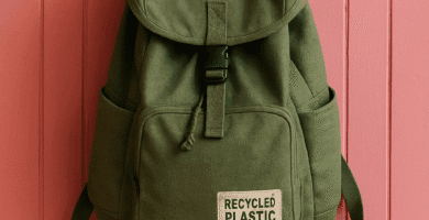 mochila verde hecha con plástico reciclado colgada de pared rosa